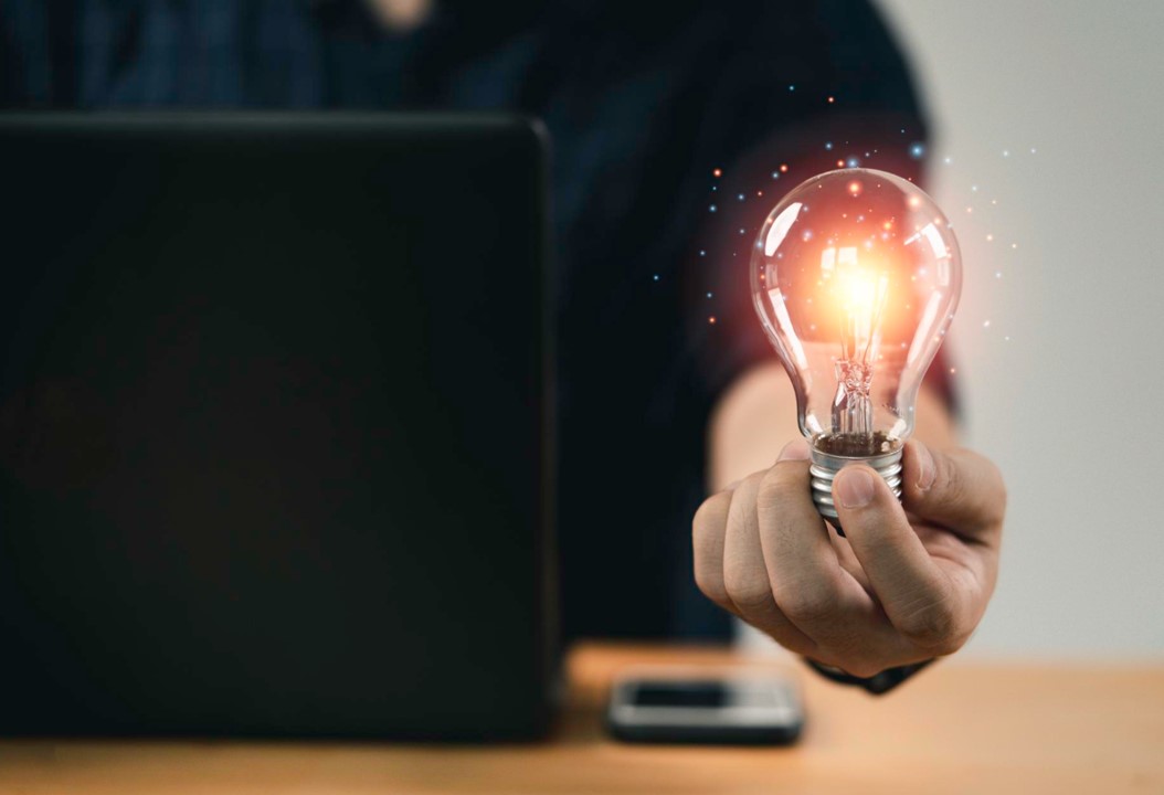 Mano de hombre de negocios sosteniendo una bombilla con luz brillante para pensar de forma creativa e inteligente en busca de inspiración e innovación con el concepto de red